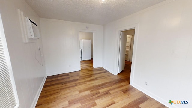 unfurnished room featuring light hardwood / wood-style flooring and a textured ceiling