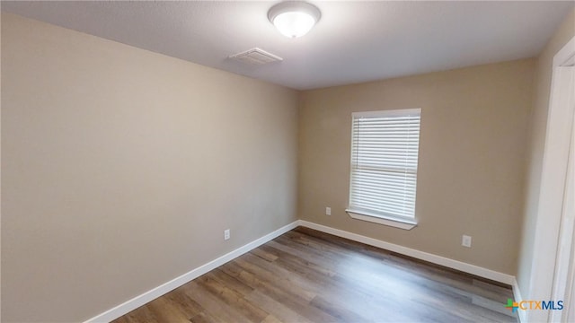 unfurnished room with hardwood / wood-style floors