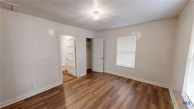 unfurnished bedroom featuring dark hardwood / wood-style flooring, a closet, and a textured ceiling