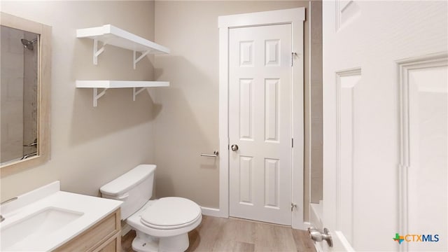 bathroom with a shower, wood-type flooring, vanity, and toilet