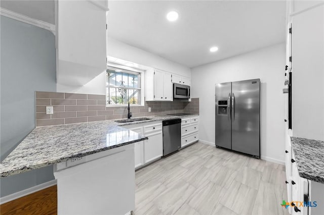 kitchen with white cabinets, sink, light stone countertops, tasteful backsplash, and stainless steel appliances