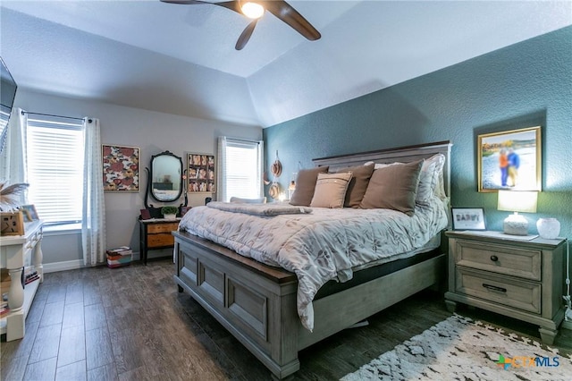 bedroom featuring ceiling fan, dark wood-type flooring, multiple windows, and lofted ceiling