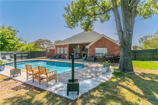 view of pool with a patio area and a lawn