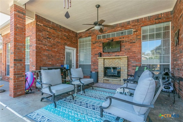 view of patio / terrace with ceiling fan and an outdoor fireplace