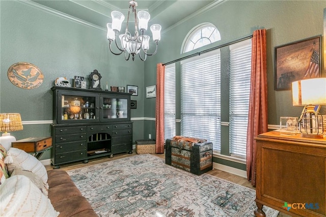 living room with crown molding, a chandelier, and light hardwood / wood-style flooring