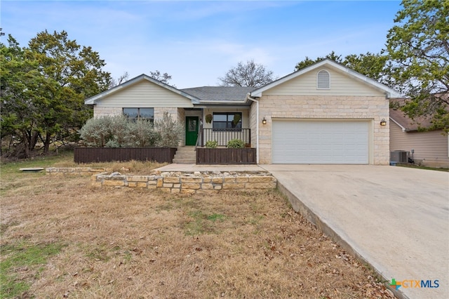 single story home with a garage, a front lawn, central AC unit, and covered porch