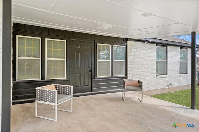 entrance to property with crawl space, brick siding, and board and batten siding