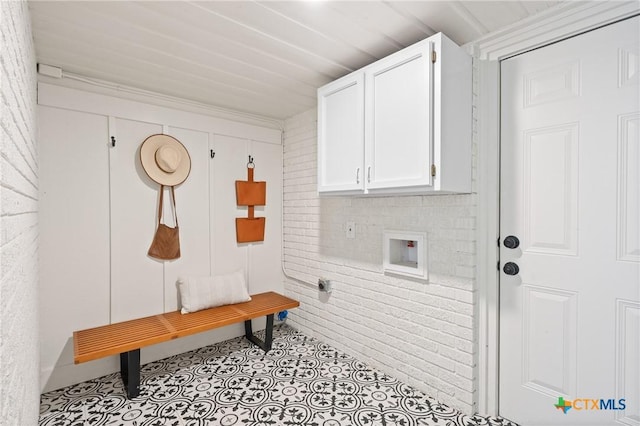 mudroom featuring brick wall