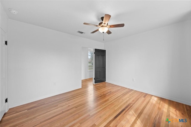 unfurnished room with visible vents, light wood-style flooring, baseboards, and ceiling fan