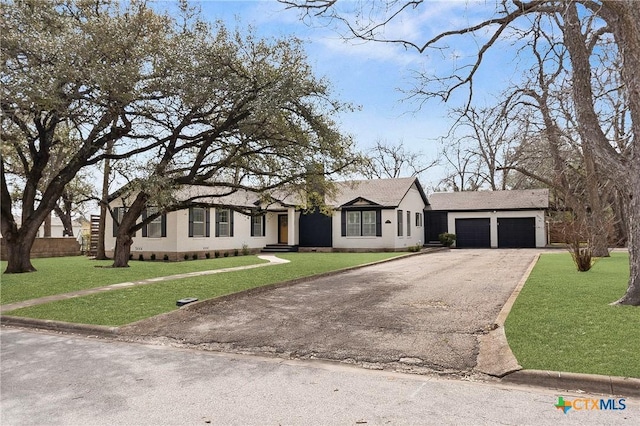 view of front of house with driveway, an attached garage, and a front lawn