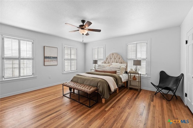 bedroom with light wood-style flooring, multiple windows, and baseboards