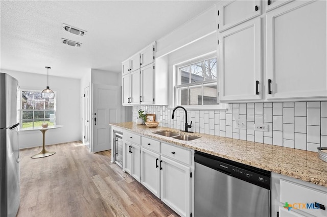 kitchen featuring visible vents, white cabinets, appliances with stainless steel finishes, and a sink