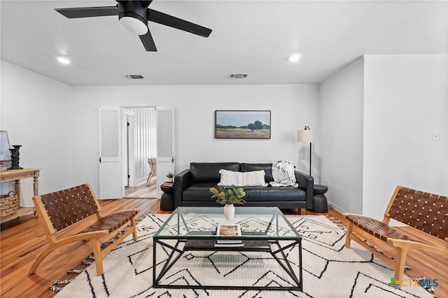 living area with recessed lighting, visible vents, wood finished floors, and a ceiling fan