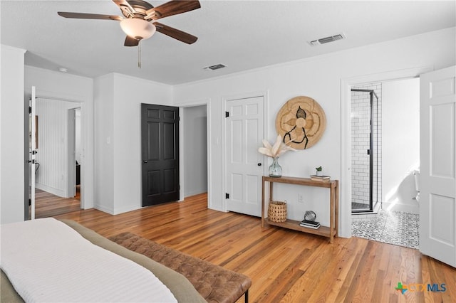 bedroom with a ceiling fan, crown molding, light wood-style floors, and visible vents