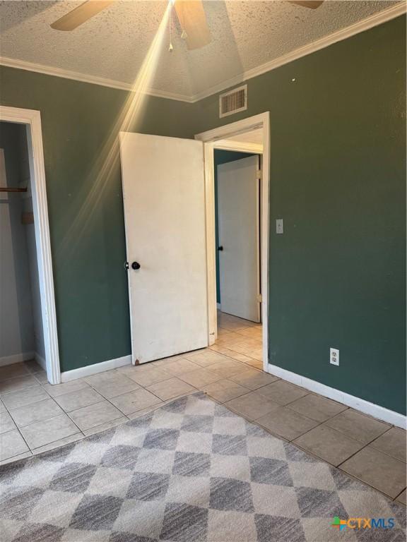 unfurnished bedroom featuring tile patterned floors, a closet, and ceiling fan