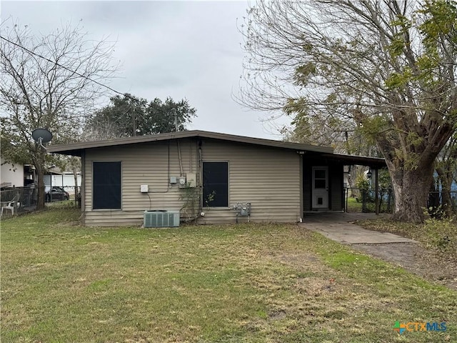 rear view of property with a yard and a carport