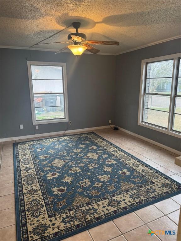 spare room featuring crown molding, tile patterned floors, and a textured ceiling