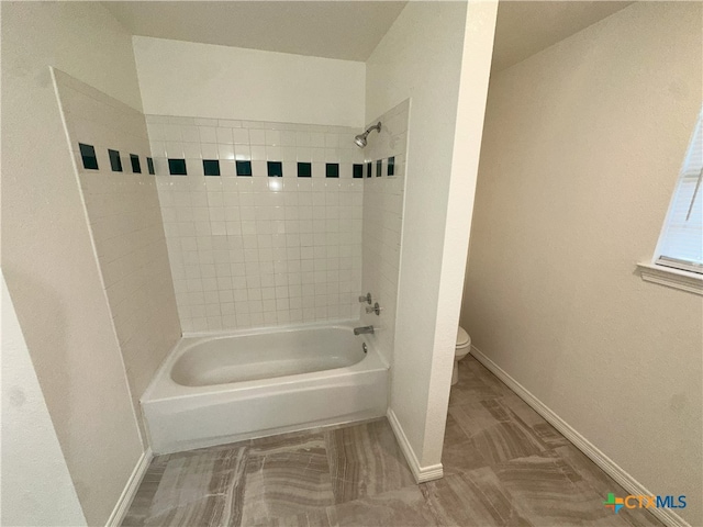 full bathroom with toilet, baseboards, and bathing tub / shower combination
