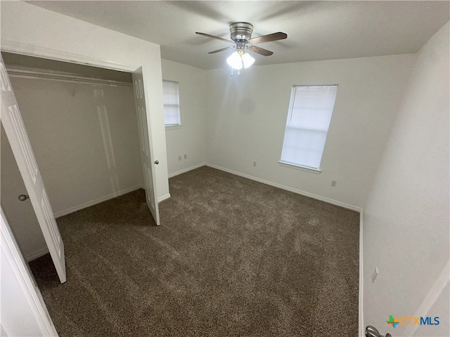 unfurnished bedroom with carpet floors, baseboards, a closet, and ceiling fan