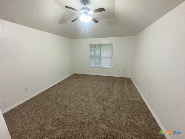carpeted spare room featuring ceiling fan and baseboards