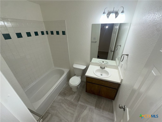full bath featuring a textured wall, toilet, vanity, and  shower combination