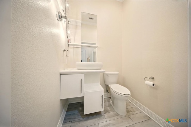 1127 Redleaf Dr, Nolanville, TX 76559 - bathroom featuring toilet, baseboards, vanity, and a textured wall