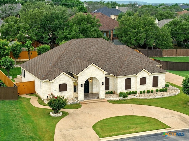 1127 Redleaf Dr, Nolanville, TX 76559 - french provincial home with stone siding, roof with shingles, and a gate