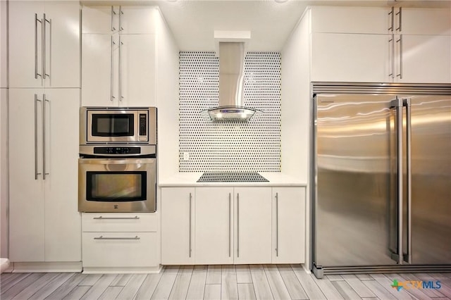1127 Redleaf Dr, Nolanville, TX 76559 - kitchen with built in appliances, white cabinets, light countertops, and wall chimney range hood