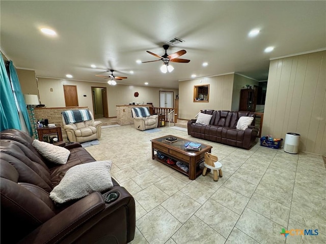 living room with light tile patterned floors, crown molding, and ceiling fan