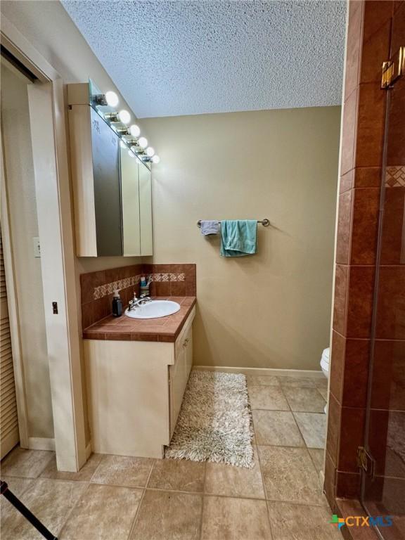 bathroom featuring vanity, toilet, and a textured ceiling