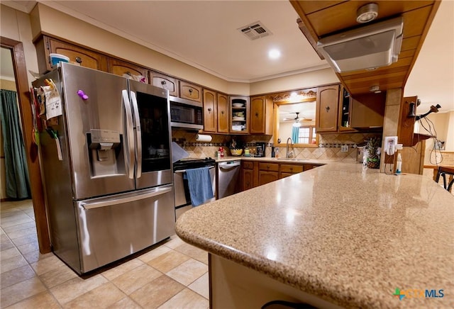 kitchen featuring sink, stainless steel appliances, ornamental molding, decorative backsplash, and kitchen peninsula