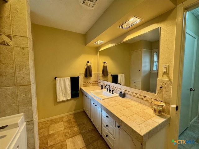 bathroom with vanity and decorative backsplash