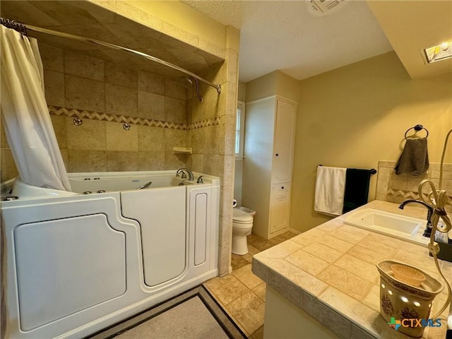 bathroom with washing machine and clothes dryer, tile patterned floors, toilet, a textured ceiling, and vanity