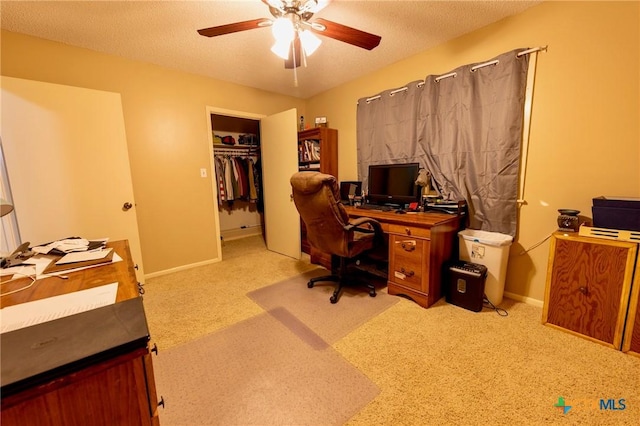 carpeted office space featuring ceiling fan and a textured ceiling