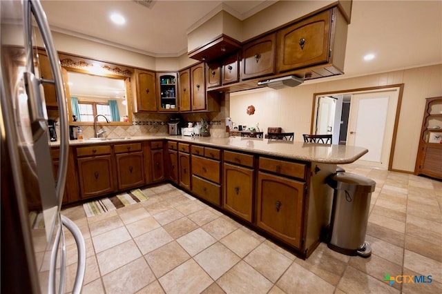 kitchen featuring sink, stainless steel fridge, tasteful backsplash, ornamental molding, and kitchen peninsula