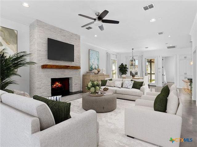 living room featuring a stone fireplace and ceiling fan