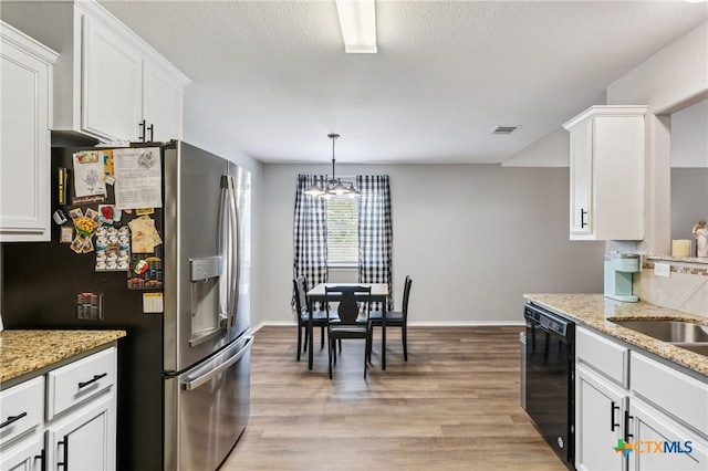 2617 Turning Creek St, Temple, TX 76504 - kitchen with white cabinets, light wood-type flooring, stainless steel fridge, black dishwasher, and light stone counters