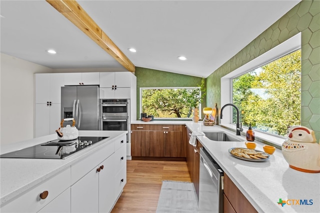 kitchen featuring white cabinetry, sink, light wood-type flooring, and appliances with stainless steel finishes