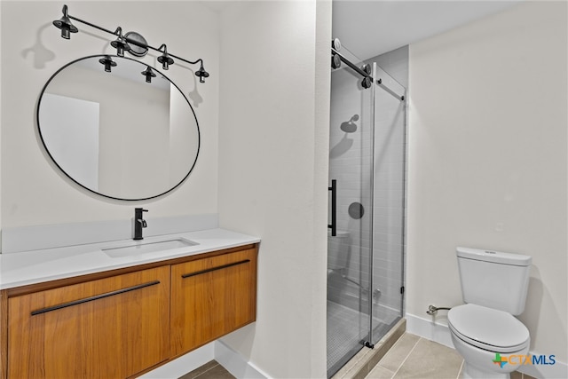 bathroom with tile patterned flooring, vanity, toilet, and a shower with shower door