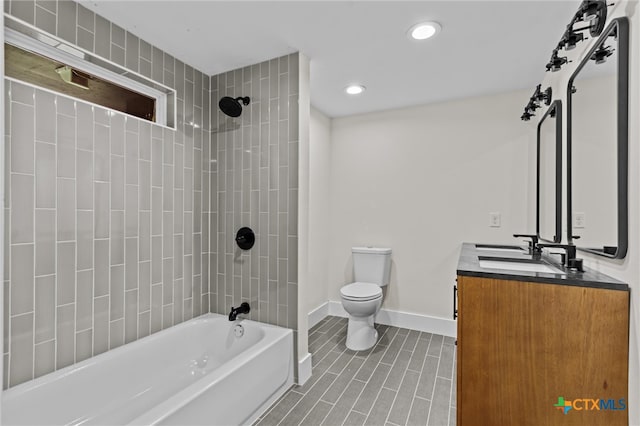 full bathroom featuring vanity, toilet, and tiled shower / bath combo