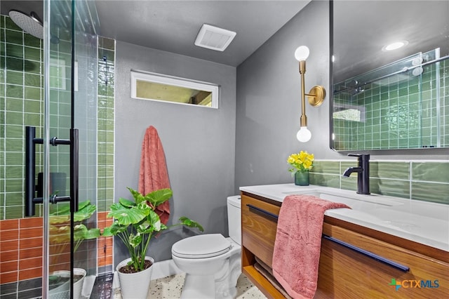 bathroom featuring toilet, an enclosed shower, vanity, and tile patterned floors