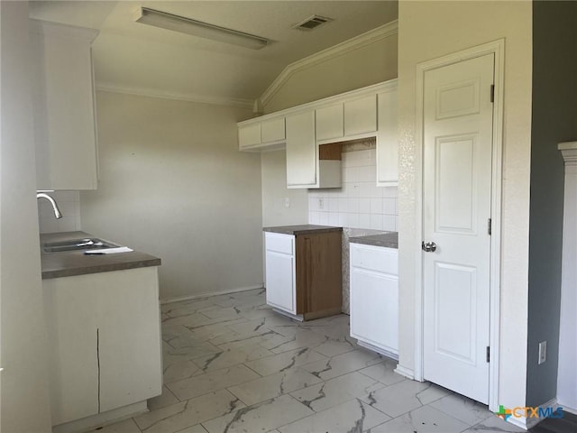 508 Redbud Dr, Copperas Cove, TX 76522 - kitchen with a sink, light marble finish floors, crown molding, white cabinets, and decorative backsplash
