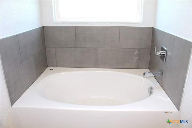 bathroom with a bathtub and a wealth of natural light