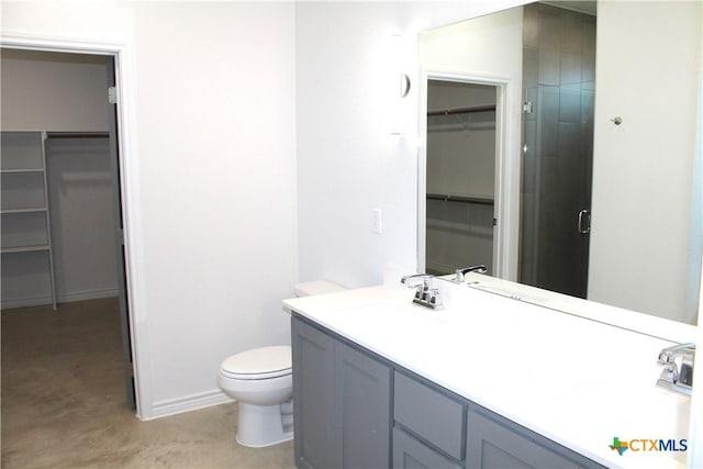 bathroom with vanity, a shower with shower door, concrete floors, and toilet