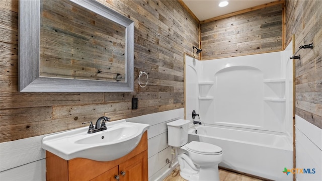 full bathroom with wood walls, bathing tub / shower combination, toilet, and vanity