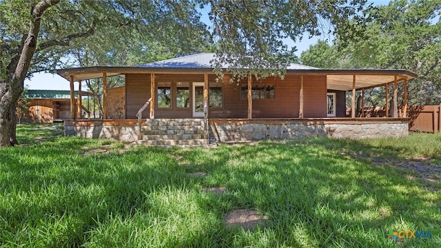 rear view of property featuring a yard