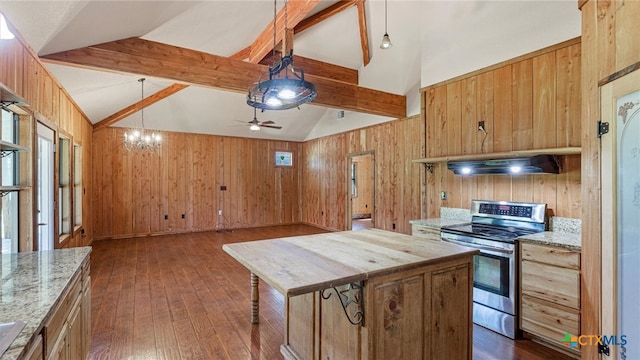 kitchen with beamed ceiling, wooden walls, a center island, stainless steel stove, and dark hardwood / wood-style flooring