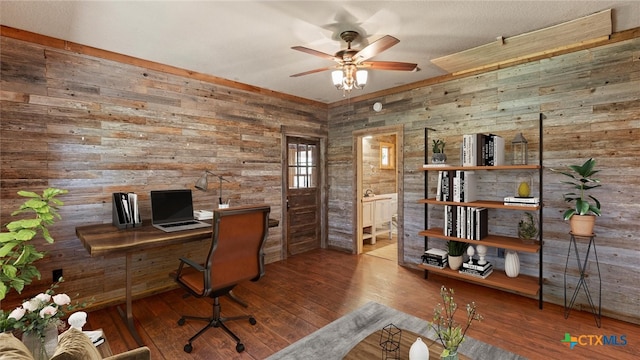 home office with wood walls, wood-type flooring, and ceiling fan