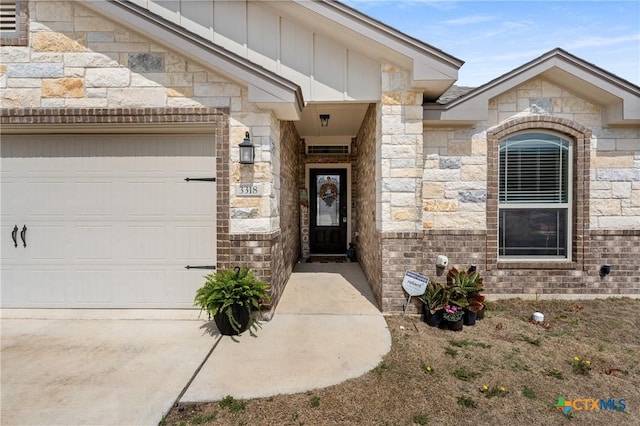 property entrance with stone siding, brick siding, board and batten siding, and an attached garage