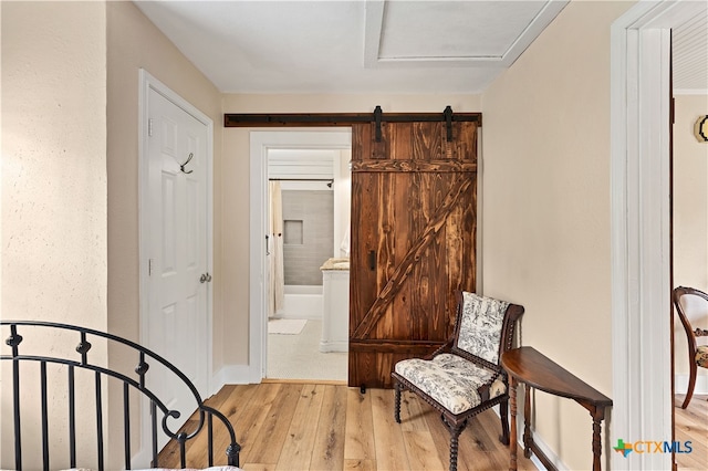 living area with light hardwood / wood-style floors and a barn door